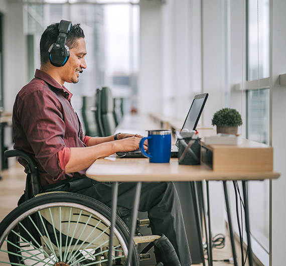 Man with headset on while using laptop